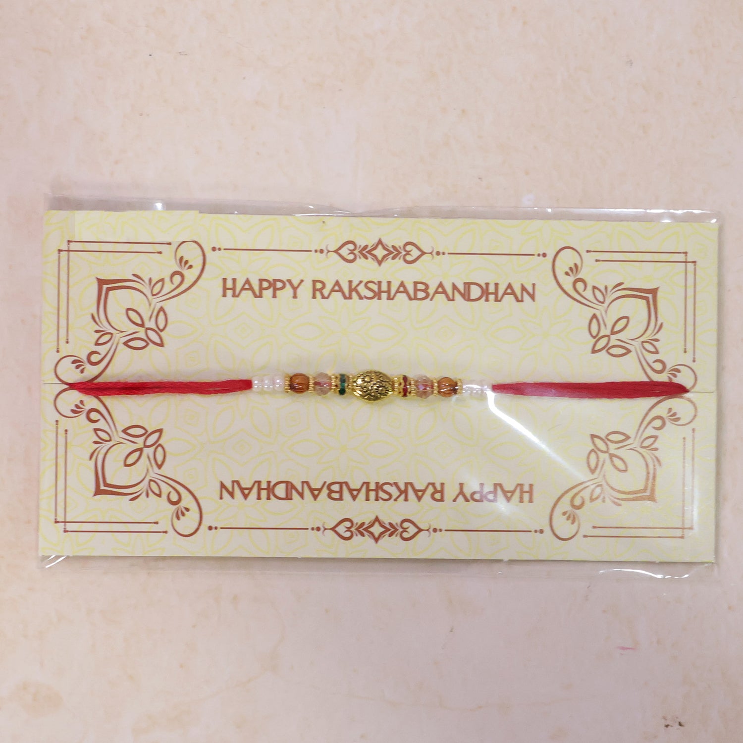 Red Thread Rakhi with Floral Gold Oval Charm and Multicolour Beads