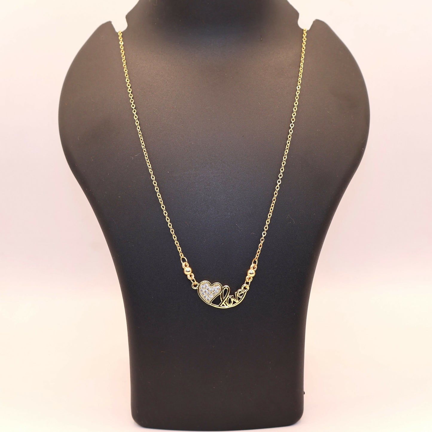 Stylish gold heart love pendant necklace showcasing pavé-set zirconia stones on a delicate chain