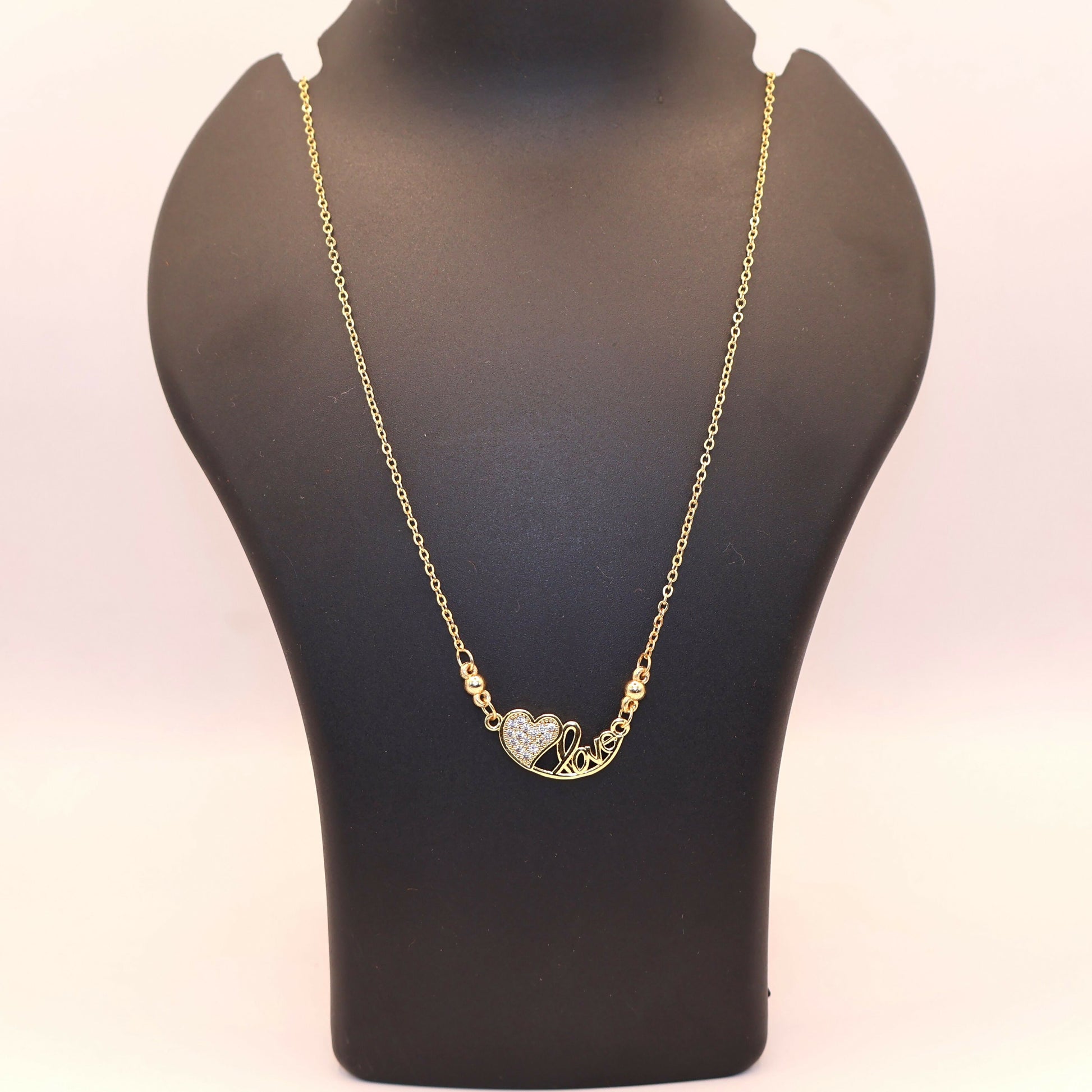 Stylish gold heart love pendant necklace showcasing pavé-set zirconia stones on a delicate chain