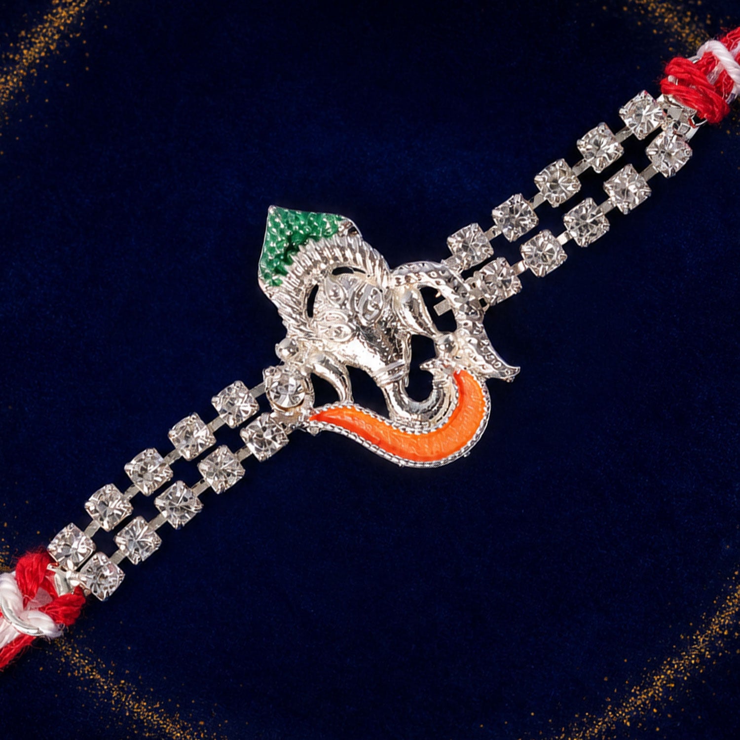 Traditional Rakhi showcasing Ganesha Charm, red stone accents and gift look for Gift