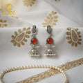 Antique Silver Peacock Jhumka Earrings – Red Stone & Pearl Drops