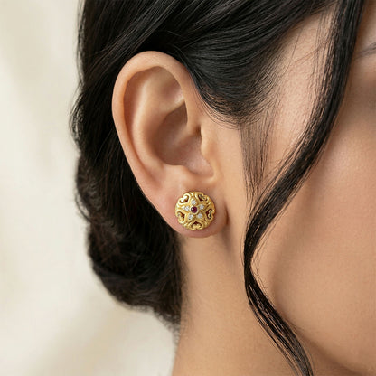 Elegant gold stud earrings featuring intricate floral design and attached stones