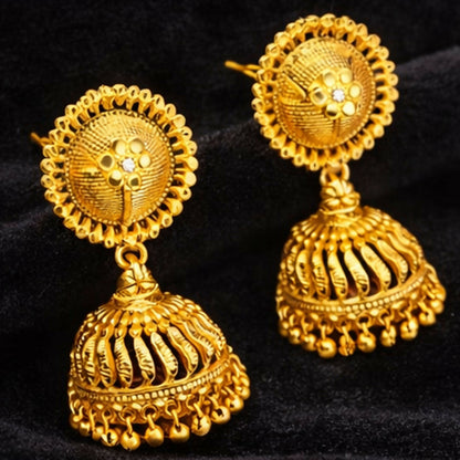 Close-up of gold plated jhumka earrings showing dome-shaped temple style carving