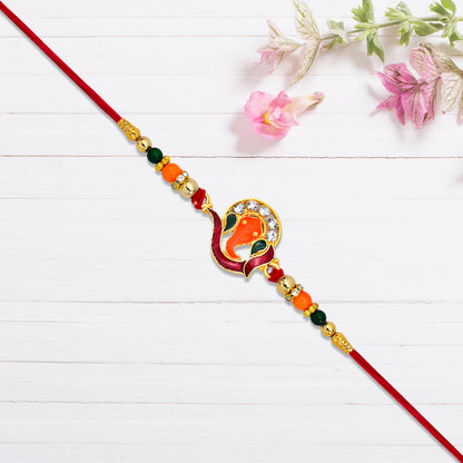 Close-up of red and green bead accents on Golden Ganesha Rakhi