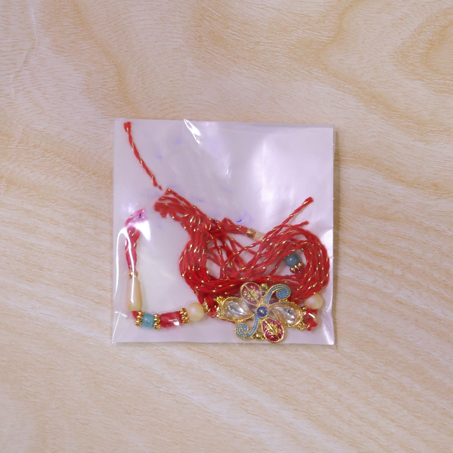 Jewel Floral Rakhi with Red Blue Beads and Bright Traditional Celebration Styling
