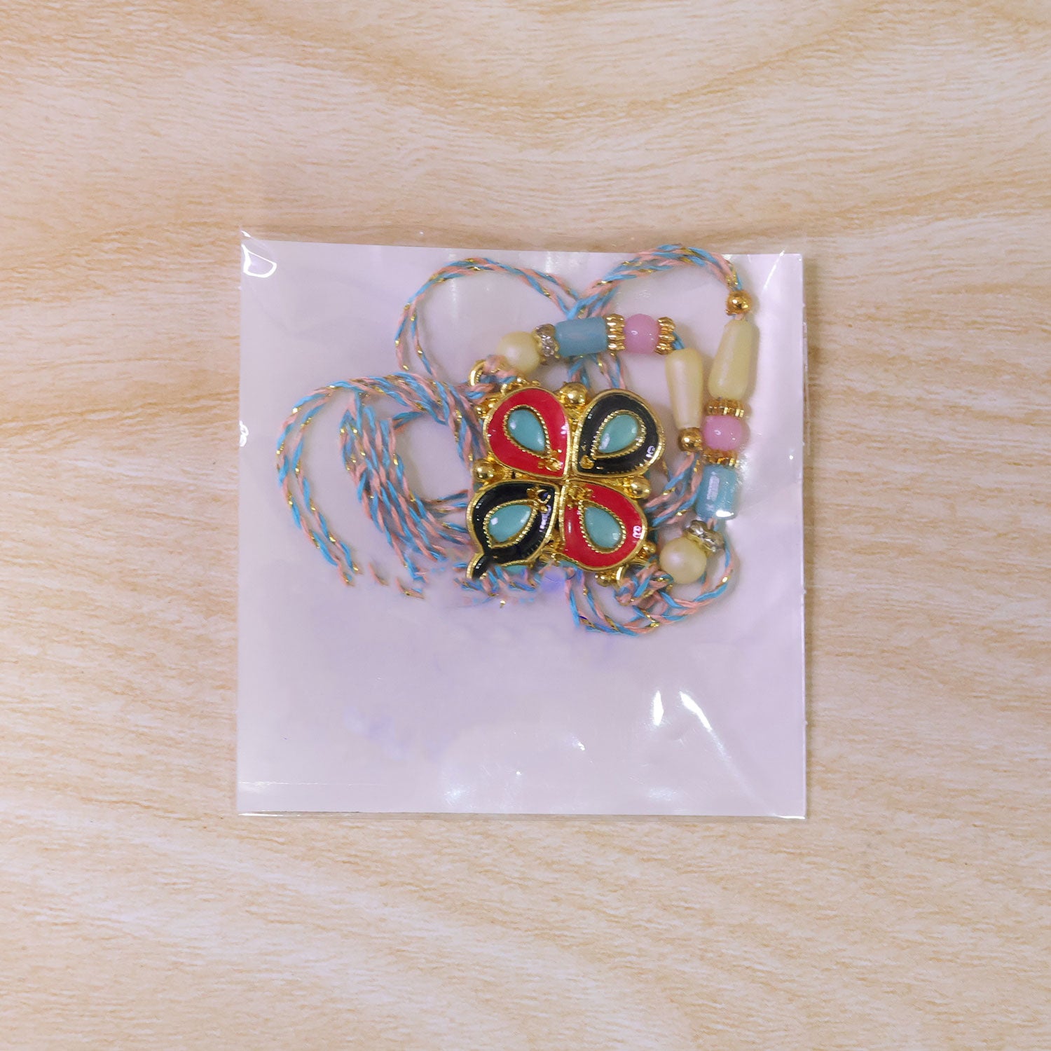 Four-Petal Floral Rakhi with Cream Thread, Multicolor Enamel and Floral Motif Design