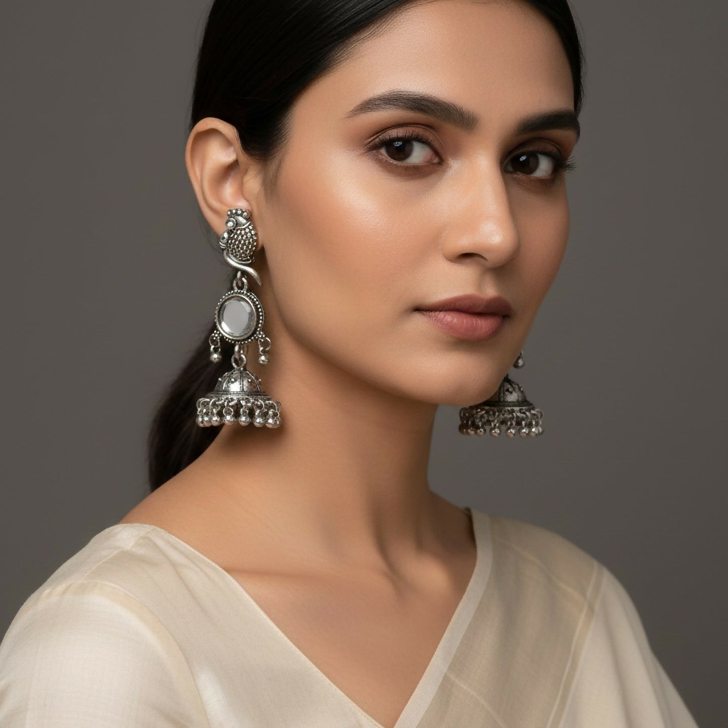 Close-up of traditional oxidised silver jhumka earrings with ghungroo bead danglers