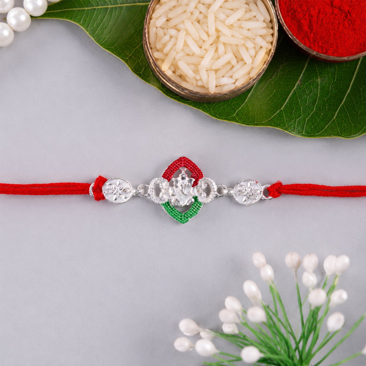 Silver Green Floral Rakhi with Red Thread and White Side Charms