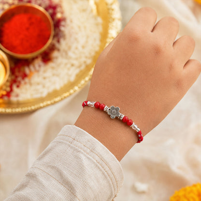 Red Braided Rakhi with Silver Flower Charm and Crystal Bead Accents