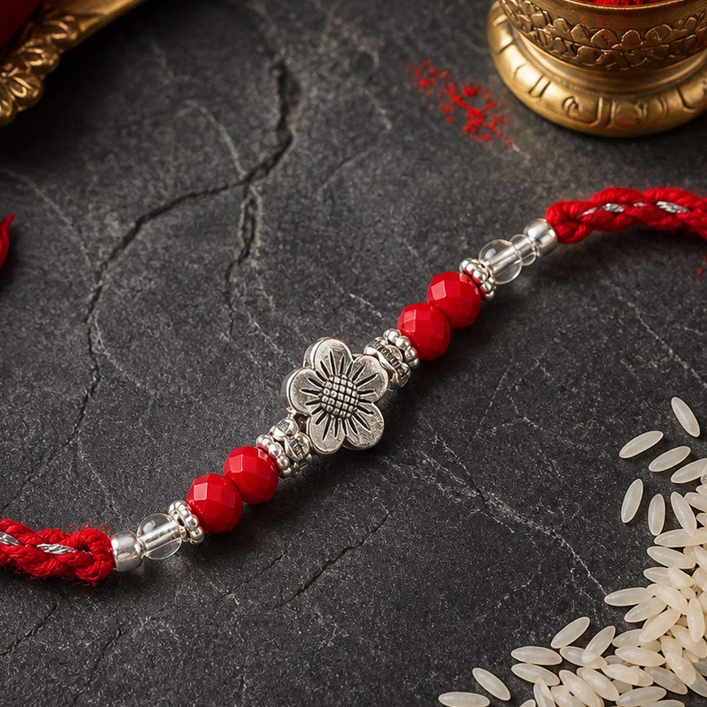 Red Braided Rakhi with Silver Flower Charm and Crystal Bead Accents