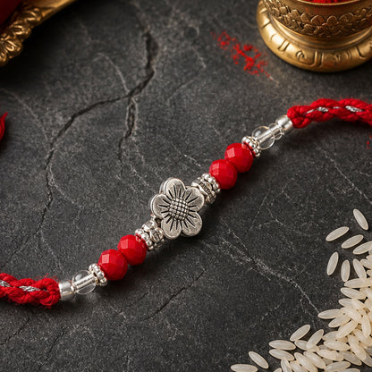 Red Braided Rakhi with Silver Flower Charm and Crystal Bead Accents