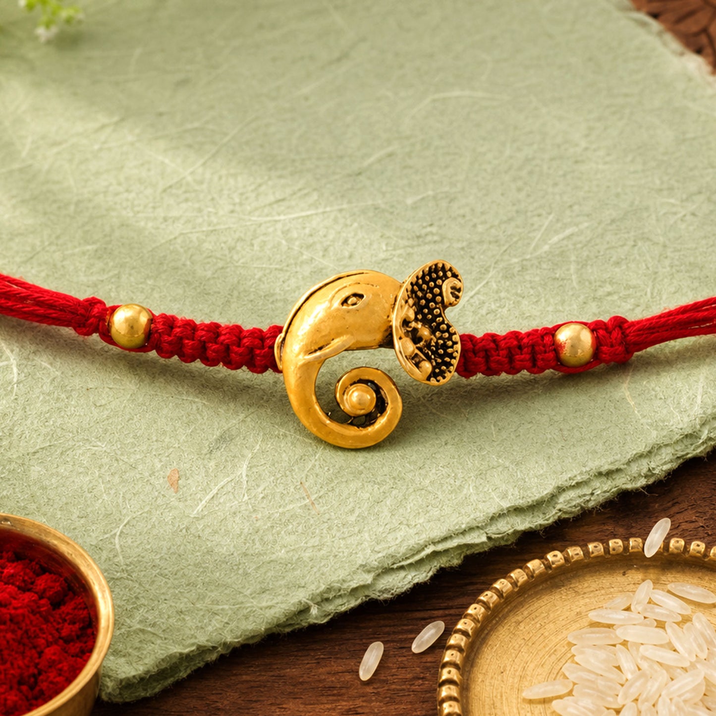 Red Thread Rakhi with Antique Gold Elephant-Shaped Charm Pendant