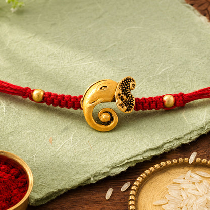 Red Thread Rakhi with Antique Gold Elephant-Shaped Charm Pendant