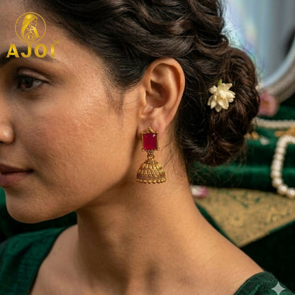 Close-up of temple gold earring with deity and floral motifs