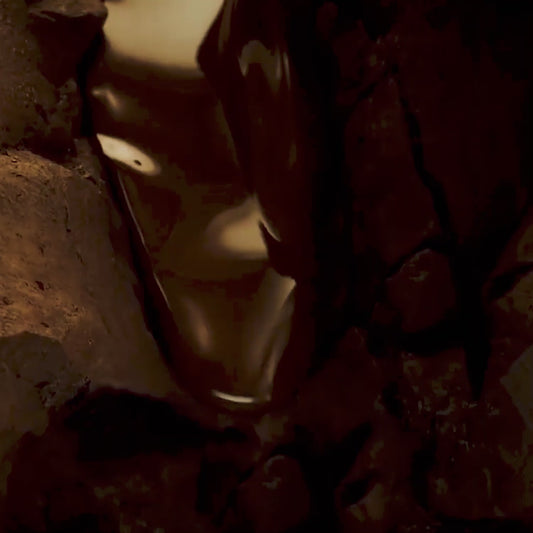 Close-up view of dark brown melted chocolate dripping over a rough, textured surface.