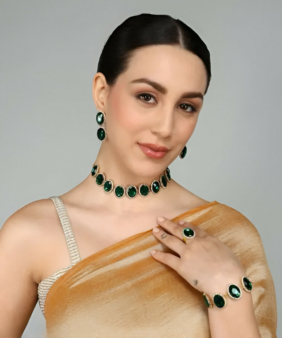 Close-up of emerald green crystal necklace and earrings in silver-tone settings