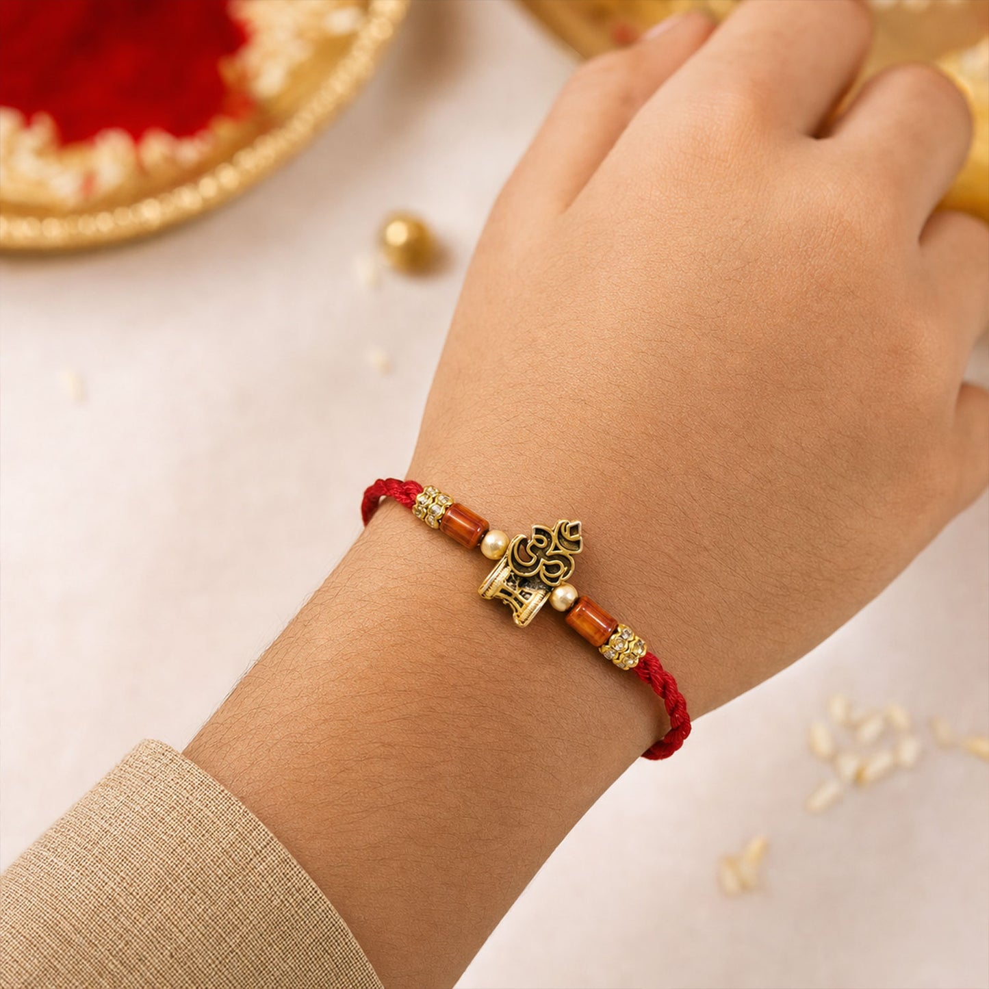 Red Braided Rakhi with Golden Om Pendant and Warm Amber Beads