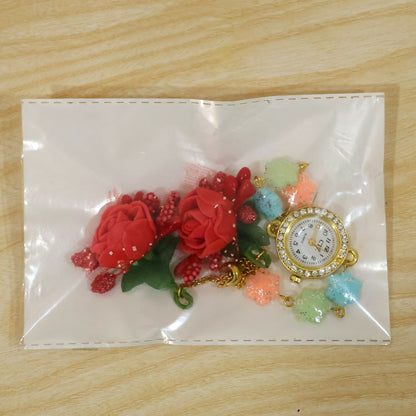 The watch and charms are visible through a clear plastic bag, with the watch face and charms separated.