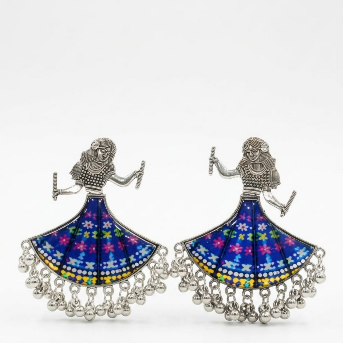 Pair of oxidized silver dancing doll earrings with blue floral skirts on a plain white background.