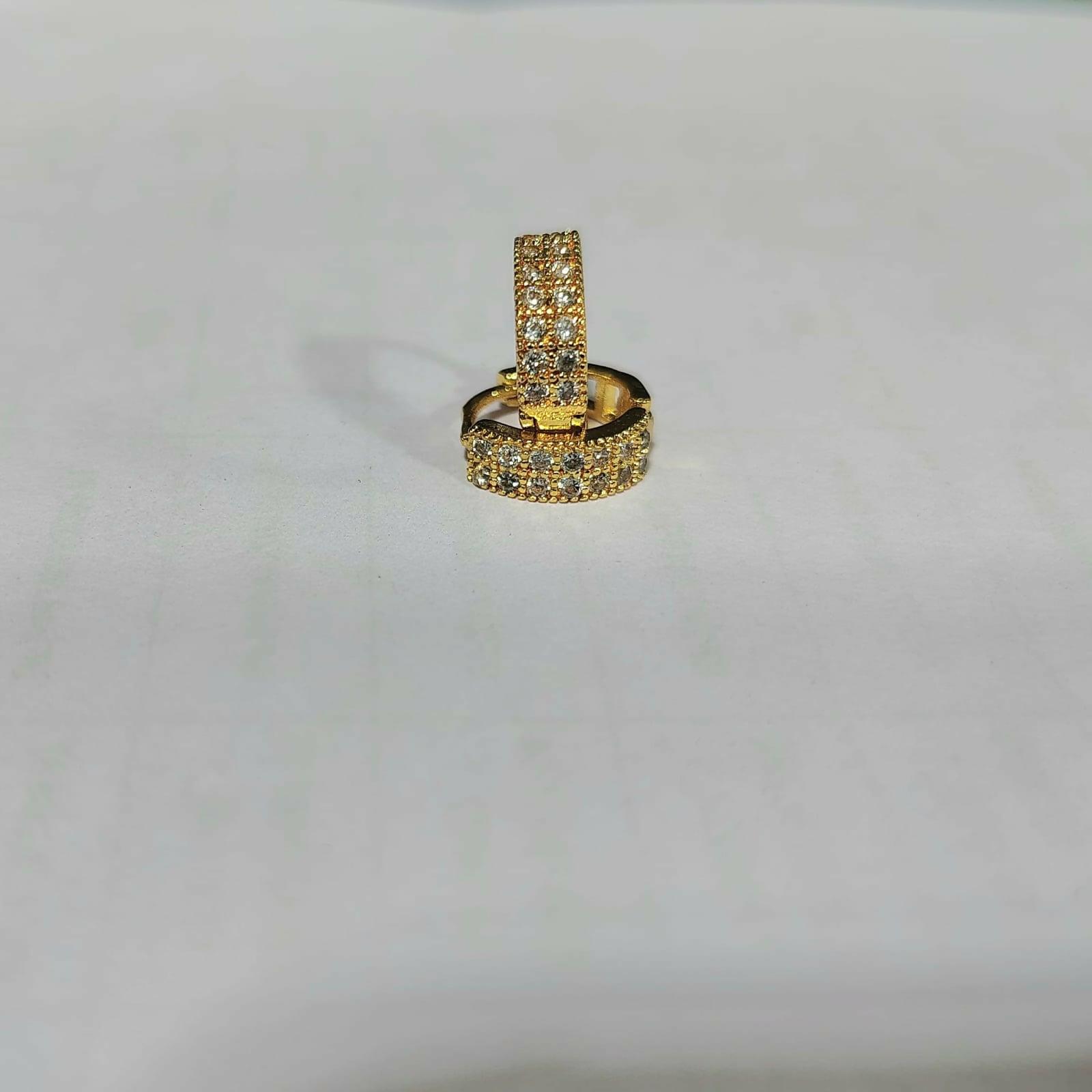 Single gold plated huggie hoop earring featuring multicolored CZ stones