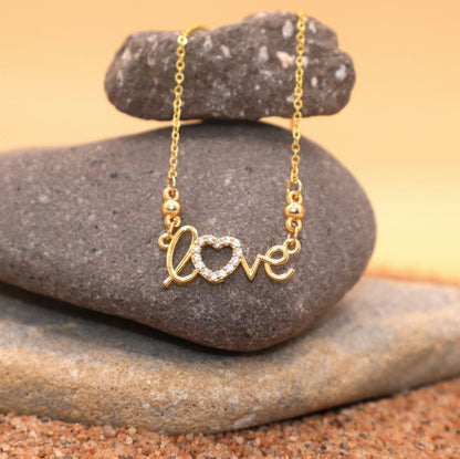 Close-up of gold plated "LOVE" heart necklace pendant adorned with CZ stones for women and girls