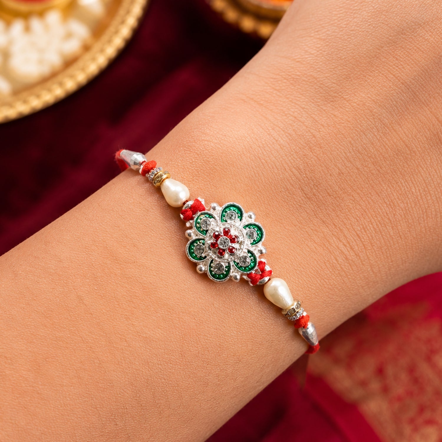 Green Flower Rakhi with Red Beads and Pearl Thread Styling