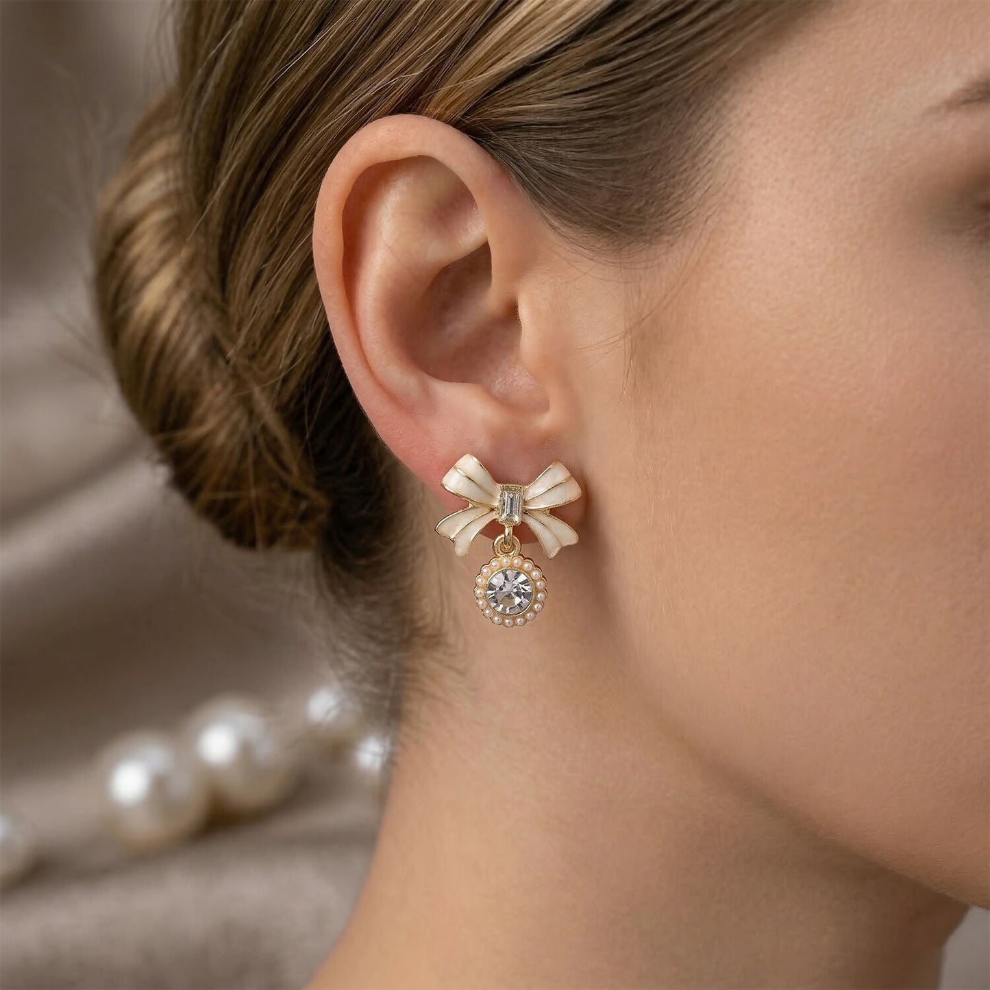 Close-up of bow ribbon design on crystal drop earrings