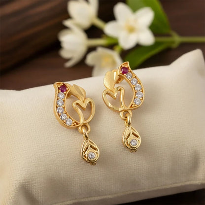 Gold earrings featuring open-heart motif with ruby-toned stone