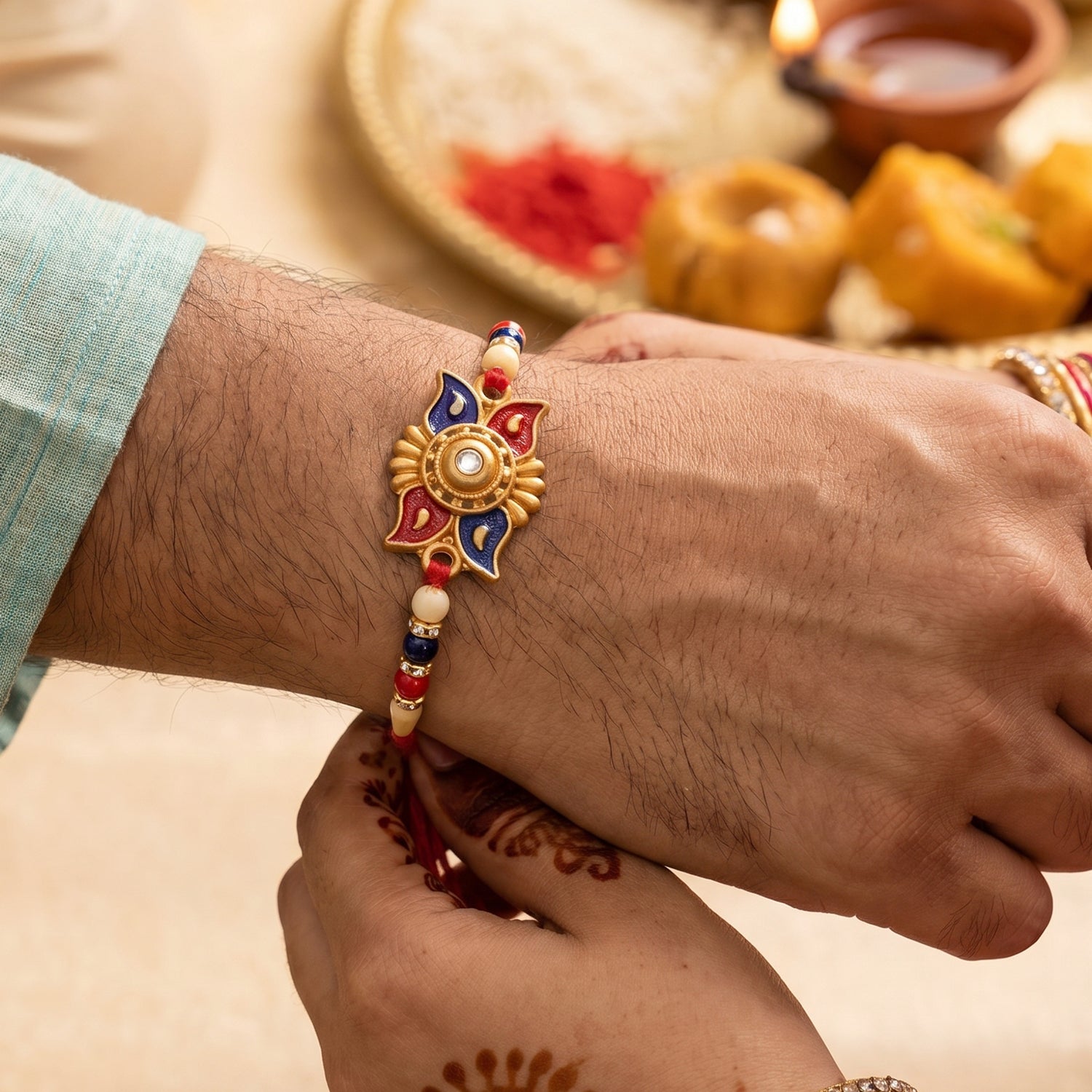 Gold Sunburst Rakhi with Blue Red Beads and Pearl Accents