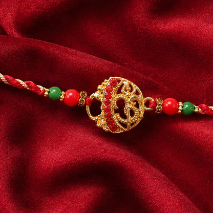 Golden Red Diamond Om Trishul Rakhi with Green Beads and Twisted Thread