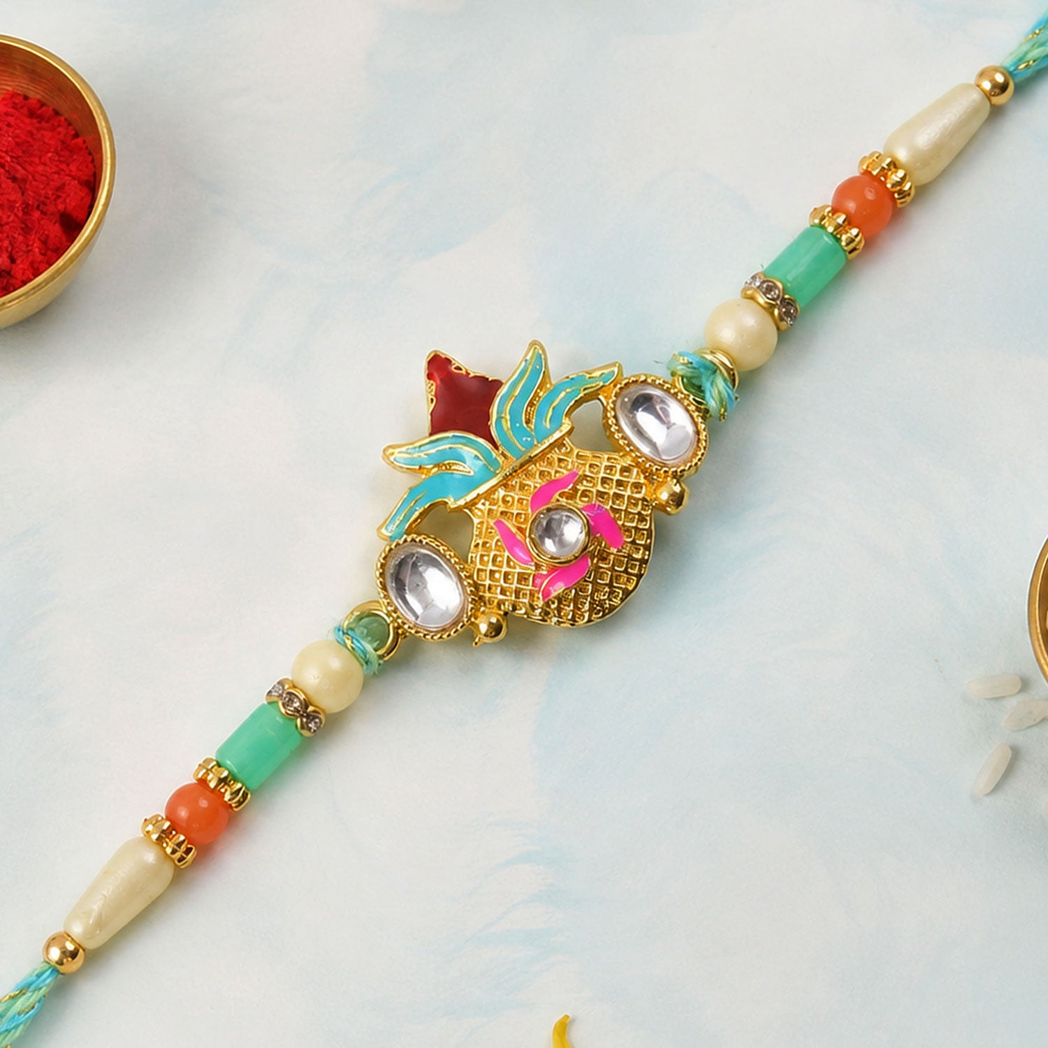 Sacred Nariyal Kalash Golden Metallic Motif Rakhi with Sea Green & Coral Beads