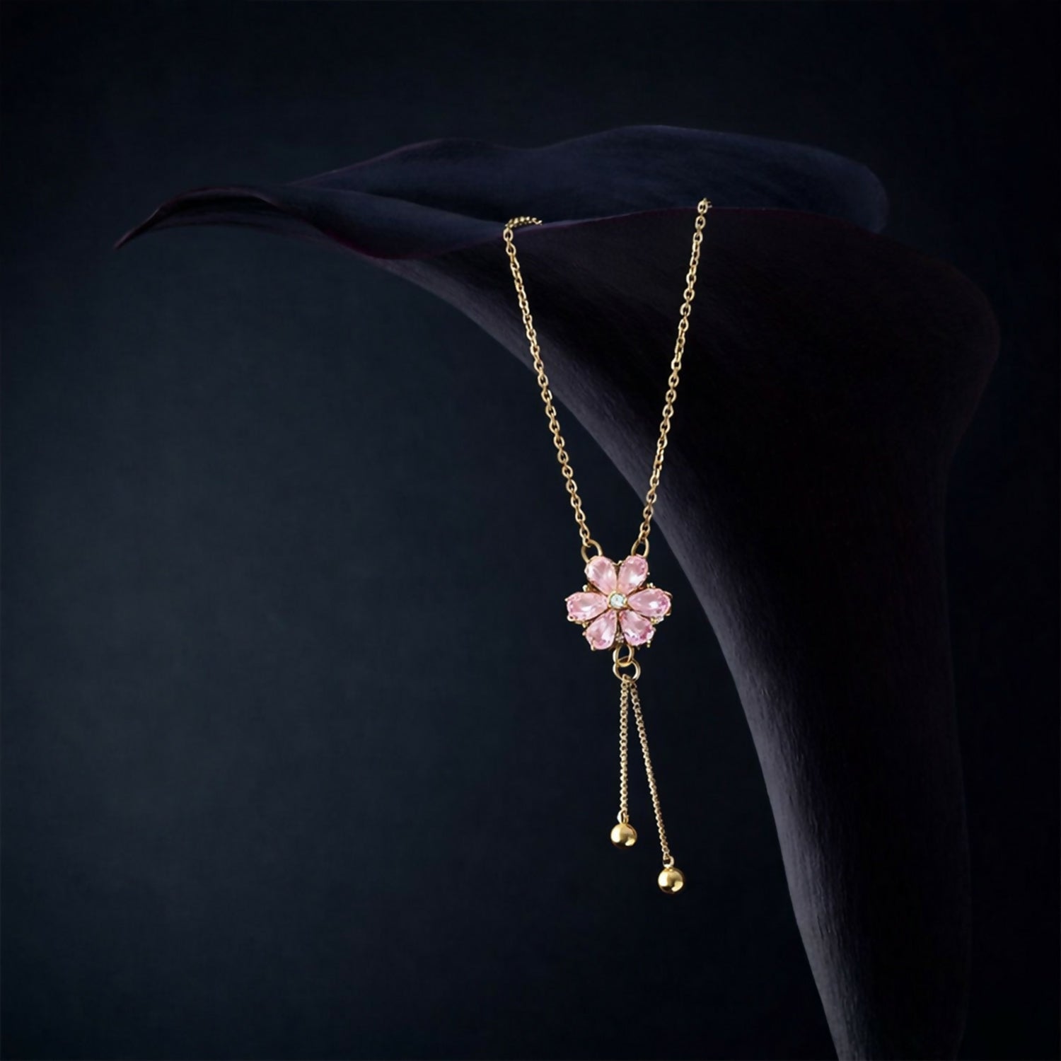 Stylish twin drop tassels with polished bead accents hanging from a pink crystal pendant necklace