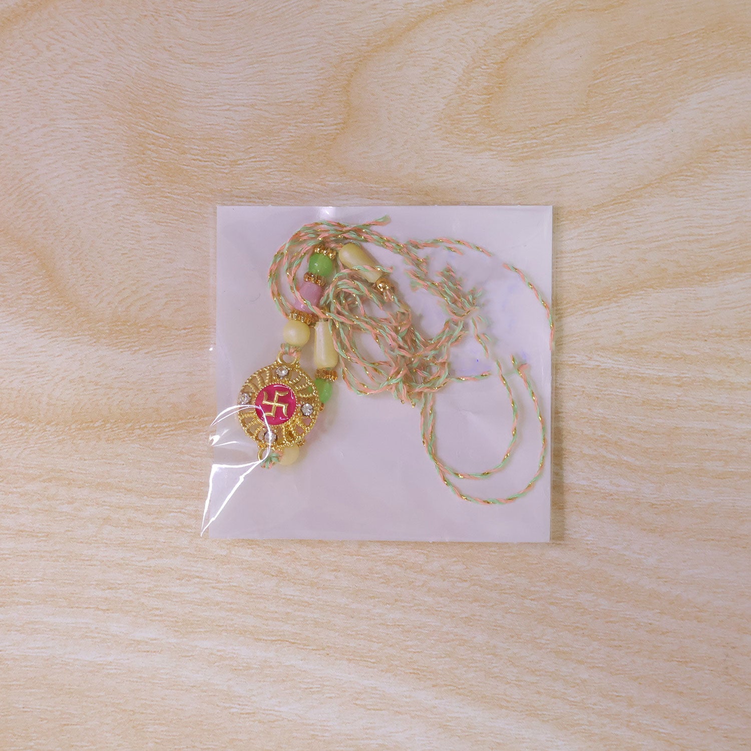 Swastik Pendant Rakhi with Kundan Stones and Pastel Beads
