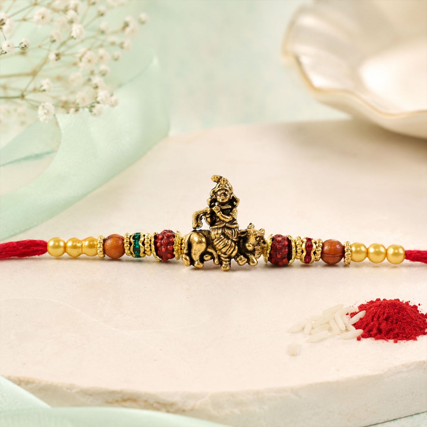 Bal Krishna Golden Devotional Rakhi with Idol Centre, Red Beads and Pearl Accents