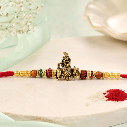 Bal Krishna Golden Devotional Rakhi with Idol Centre, Red Beads and Pearl Accents