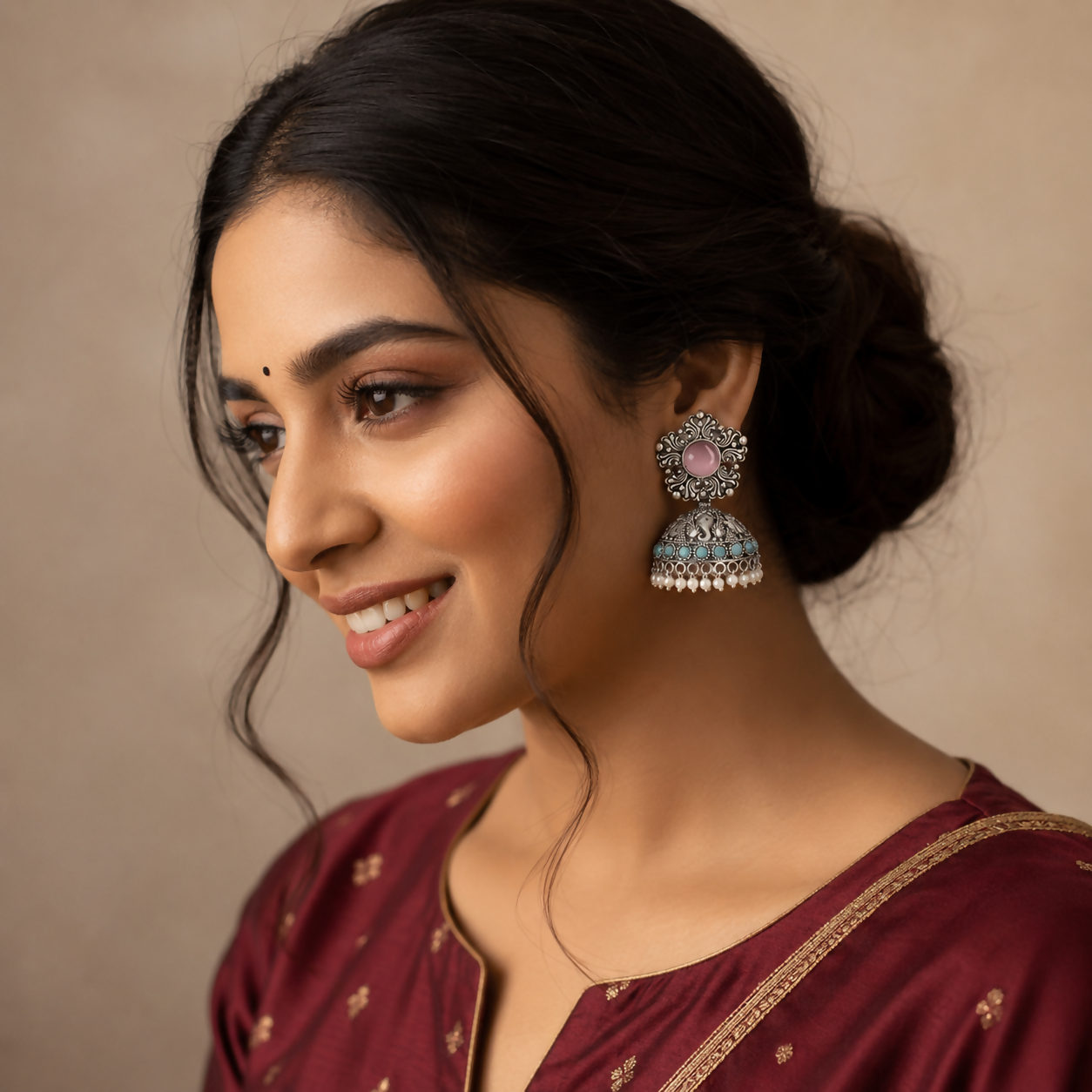 Close-up of oxidized silver jhumka earrings showing intricate pink stone details