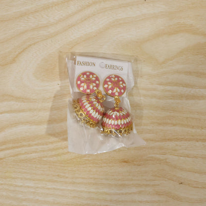 Model wearing pink round stud jhumka earrings with pearl hanging