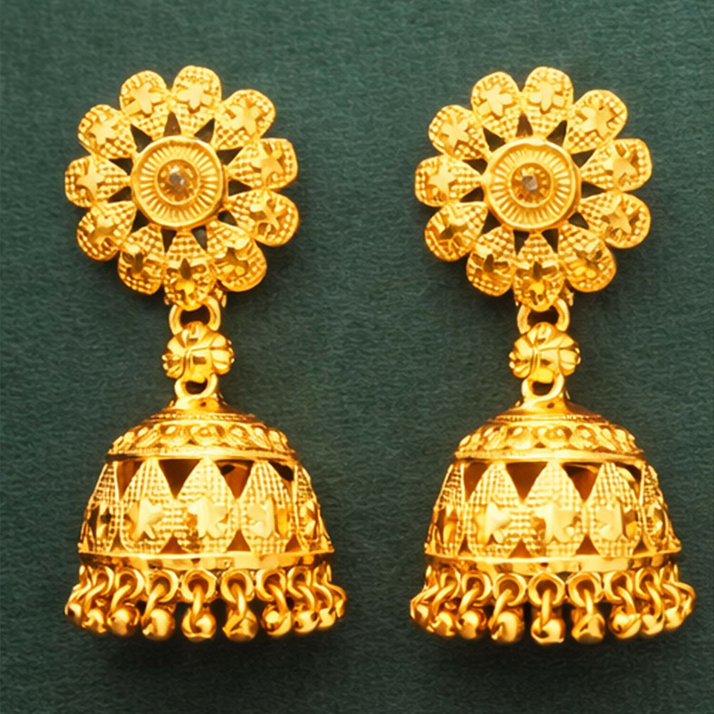 Close-up of traditional gold plated jhumka earring highlighting temple style craftsmanship