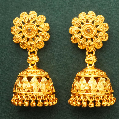 Close-up of traditional gold plated jhumka earring highlighting temple style craftsmanship