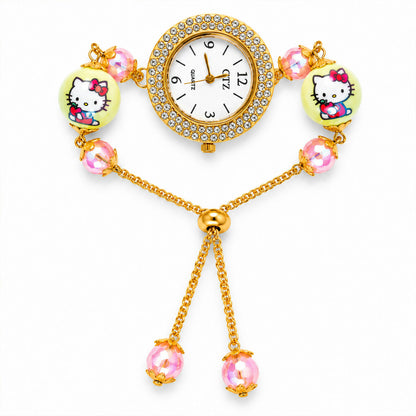 A gold-tone bracelet watch with a rhinestone-decorated dial, two yellow cartoon character beads, and smaller pink beads, on