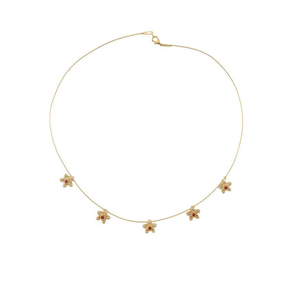 Detailed view of red & white stones on gold necklace flowers