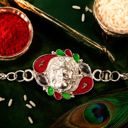 Detailed shot of the Ganesha motif on the Rakhi, showcasing its intricate craftsmanship and silver finish.