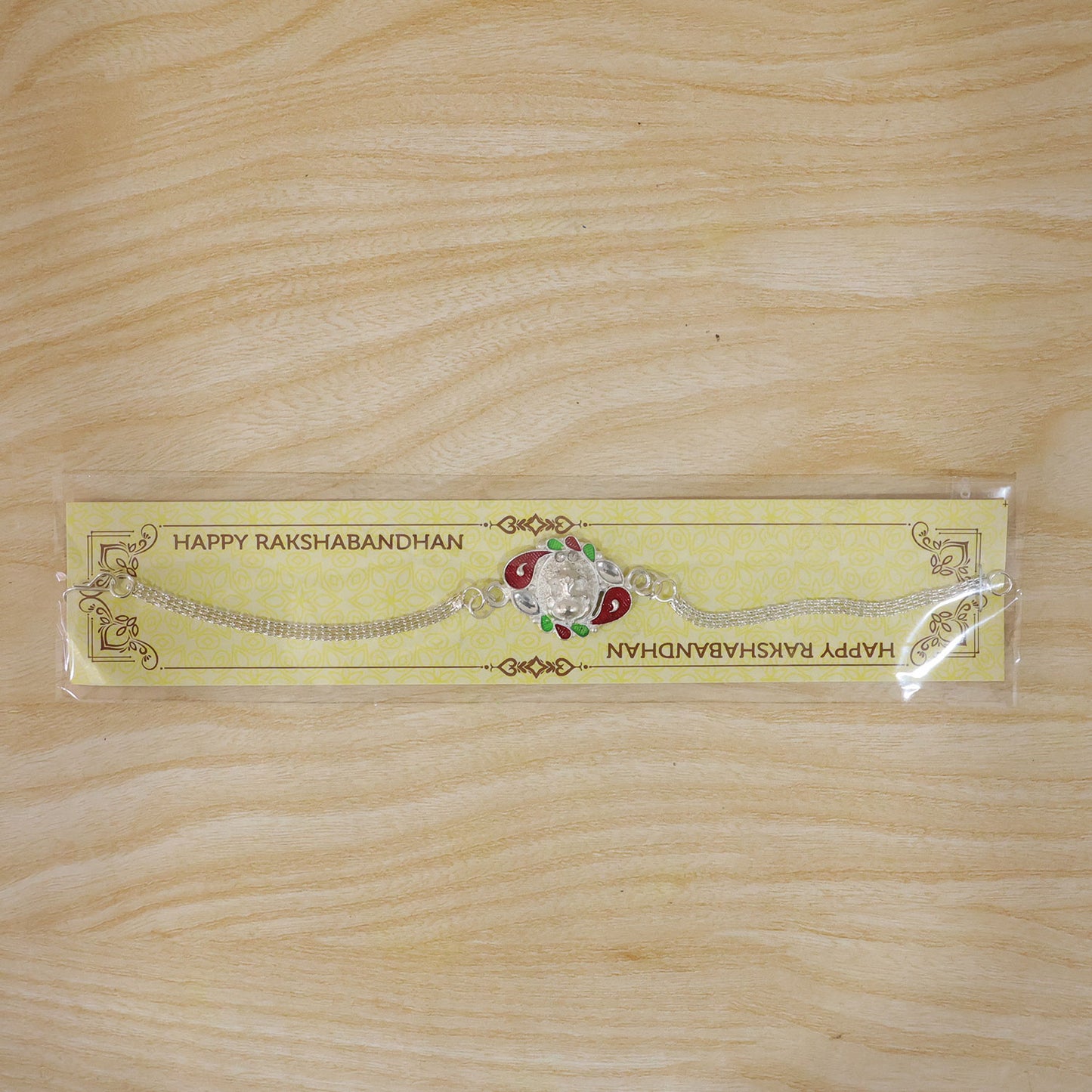 The Ganesha Rakhi subtly placed with a blurred festive background, ready for Raksha Bandhan celebrations.