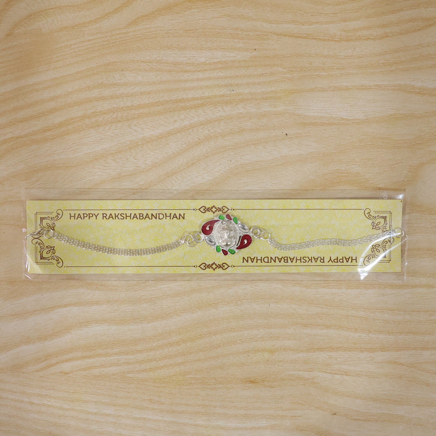 The Ganesha Rakhi subtly placed with a blurred festive background, ready for Raksha Bandhan celebrations.