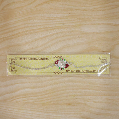 The Ganesha Rakhi subtly placed with a blurred festive background, ready for Raksha Bandhan celebrations.
