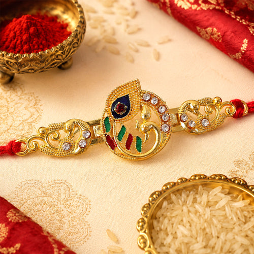 Close up of Krishna Flute Rakhi with golden enamel design and red thread.