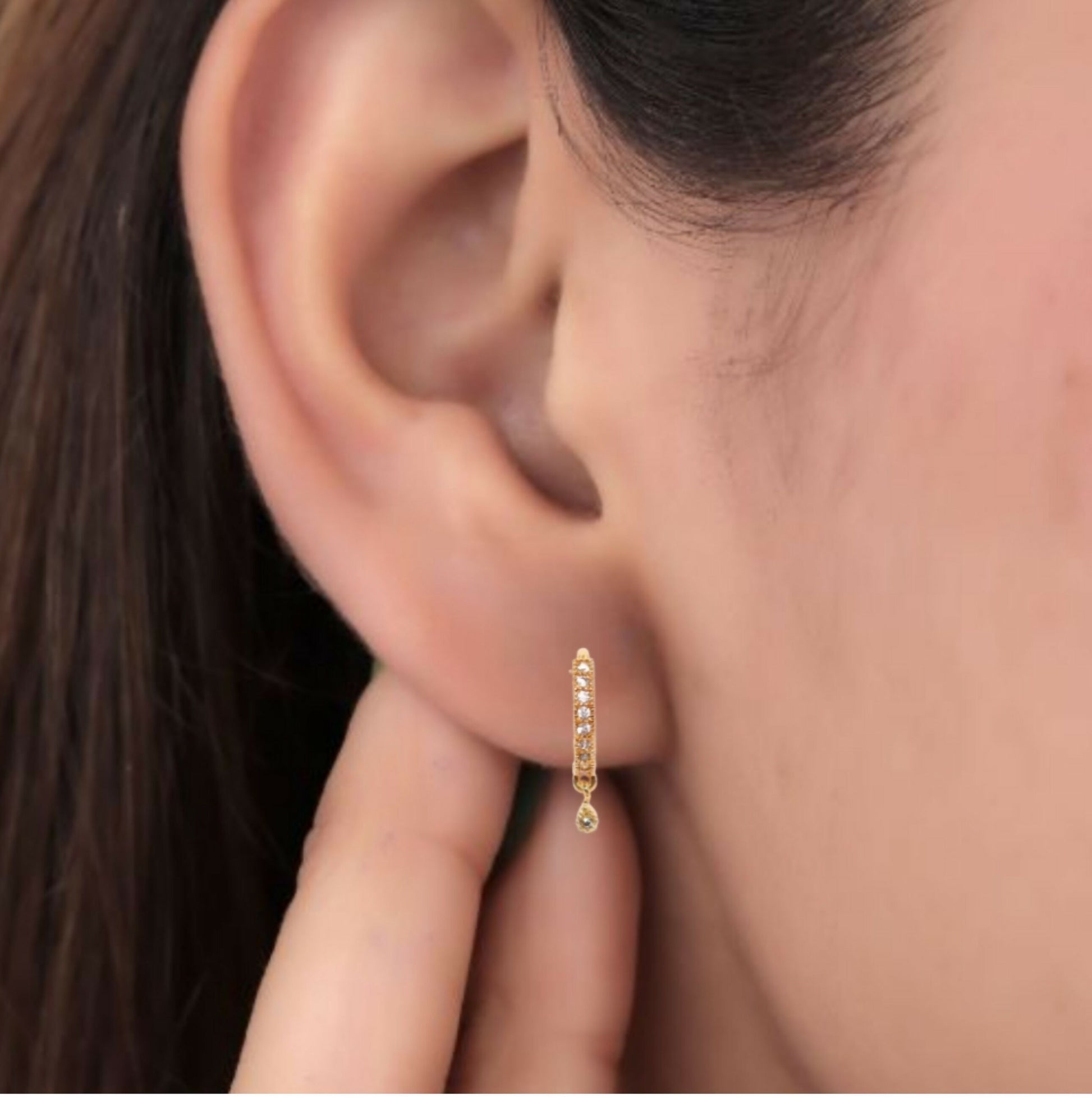 Close-up of gold plated Bali geometric floral dangle huggie earrings showing sparkling Cubic Zirconia