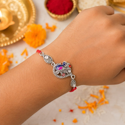 Silver-Toned Peacock Rakhi with Pink-Blue Enamel, Crystal Accents & Red Thread for Brother