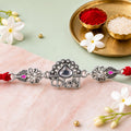 Silver-Toned Kanha Rakhi with Kundan-Style Stone, Crystal Accents & Designer Red Thread