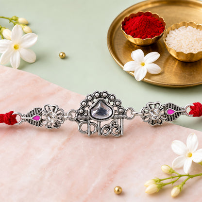 Silver-Toned Kanha Rakhi with Kundan-Style Stone, Crystal Accents & Designer Red Thread